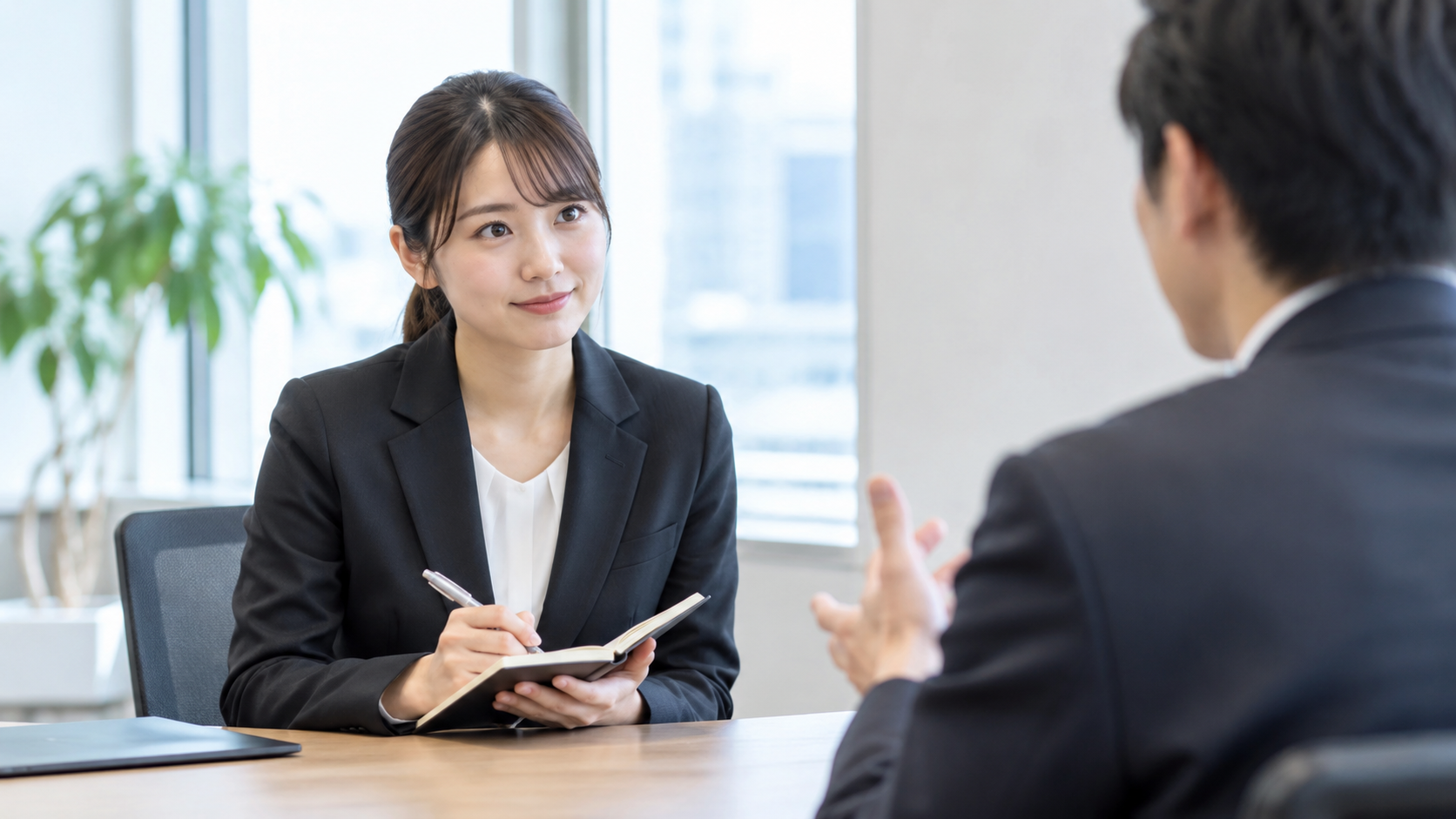 第二新卒の応募者が面接官の説明を聞きながらメモを取っている様子