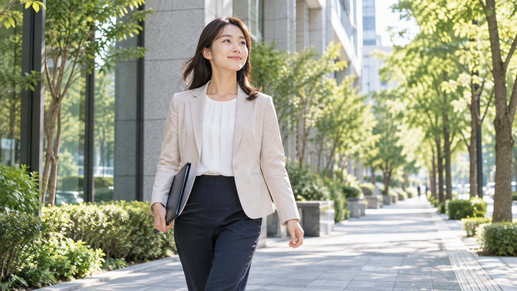 面接を終えて明るい並木道を歩く女性